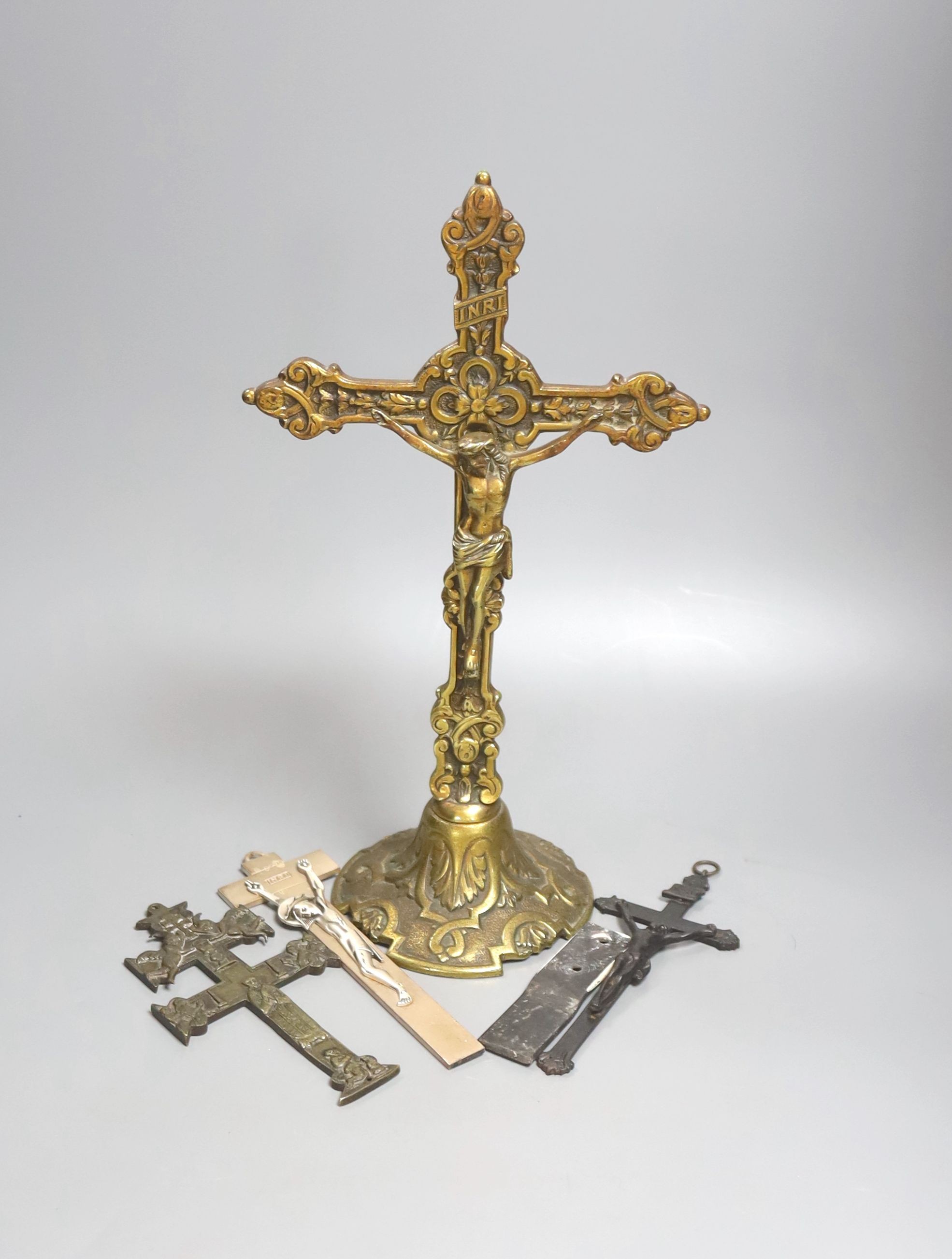 A group of four brass and metal crucifixes, largest 34cm